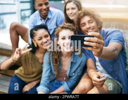 Bon temps selfie. un groupe d'étudiants prenant un selfie sur le campus. Banque D'Images