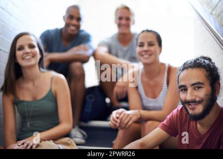 Détente avant la prochaine classe. étudiants de l'université assis sur les marches d'un escalier. Banque D'Images