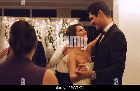 Allez-vous donner cette danse à votre nouvelle femme. un jeune couple affectueux dansant devant ses invités lors de leur réception de mariage Banque D'Images