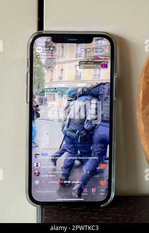 Photos d'un iphone12 live en streaming des émeutes à Paris le 1st mai 2023. Ici, un policier blessé est emmené par ses collègues. Banque D'Images
