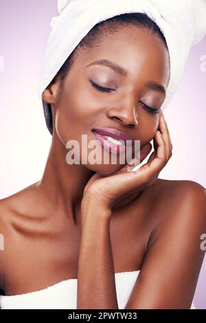 La peau douce et soyeuse parle de lui-même. Photo studio d'une belle jeune femme portant une serviette sur sa tête. Banque D'Images