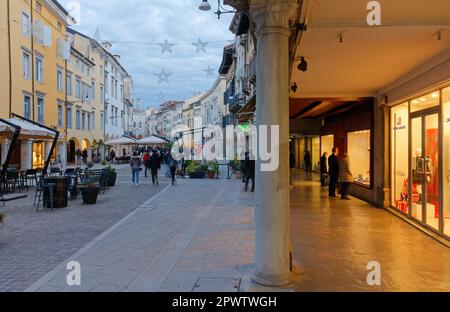 UDINE, Italie - 8 décembre 2022: La vie urbaine dans la rue Mercatovecchio en soirée d'hiver Banque D'Images