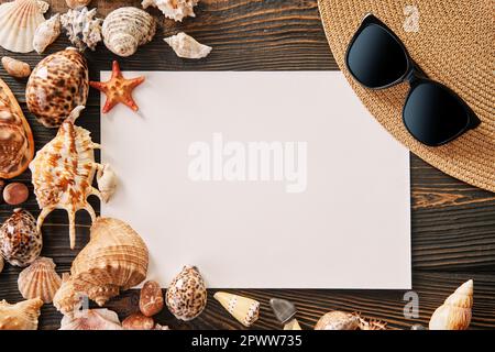 Invitation ou carte de vœux avec chapeau de paille, lunettes de soleil et divers coquillages sur fond de bois foncé, espace de copie pour le texte. Heure d'été, vacat Banque D'Images