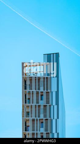 Façade et structure d'un bâtiment moderne, d'avant-garde et minimaliste recouvert de grands cristaux rectangulaires bleus et d'une terrasse dans le grenier avec un L. Banque D'Images