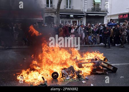 Paris, France. 01st mai 2023. Des manifestants se promèdent devant des ordures incendiées lors d'une manifestation de masse de la fête du travail dans les rues de Paris, lundi, 1 mai 2023. Des affrontements ont éclaté entre les forces de l'ordre et des manifestants radicaux qui ont frappé les fenêtres des banques alors que les syndicats ont poussé le président à abandonner un âge de retraite plus élevé. Photo de Maya Vidon-White/UPI crédit: UPI/Alay Live News Banque D'Images