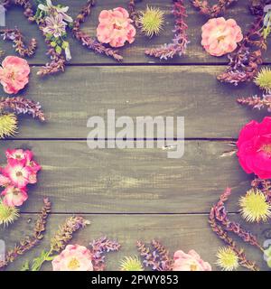 Fleurs dans un cercle sur fond en bois. Carte postale pour les vacances. Roses, géraniums, lavande, sauge et châtaignes poilues sont placés le long des bords Banque D'Images