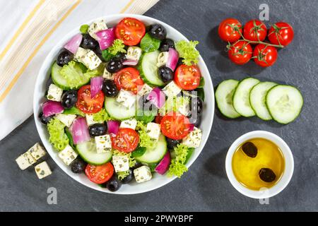Salade grecque avec tomates fraîches olives et feta fromage saine alimentation de dessus sur un repas d'ardoise Banque D'Images