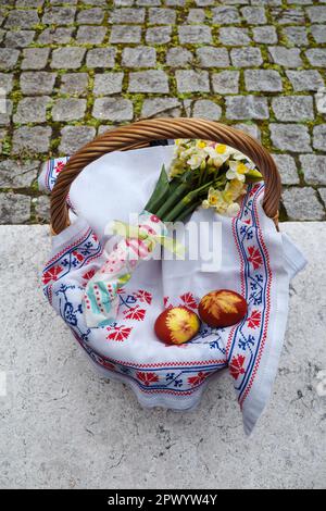 Panier de Pâques décoré de fleurs et contenant des aliments de Pâques, prêt à être apporté à l'église pour la bénédiction de pâques Banque D'Images