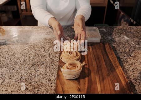 Faites de la culture à la maison en préparant des pâtes de tagliatelle roulées faites maison Banque D'Images