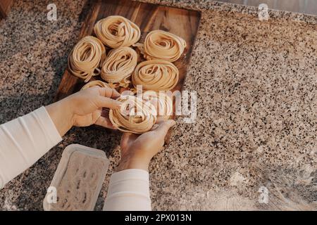 Faites de la culture à la maison en préparant des pâtes de tagliatelle roulées faites maison Banque D'Images