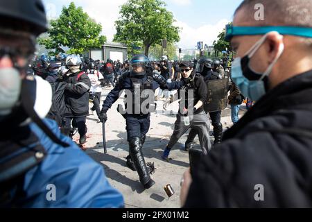 Affrontements entre manifestants et police française lors des émeutes de Mayday du 1 mai 2023 dans le centre de Paris. Beaucoup de gens se sont présentés pour exprimer leur aversion pour le président Macron et ses politiques actuelles. Officier de police français entouré de manifestants portant des masques. Banque D'Images