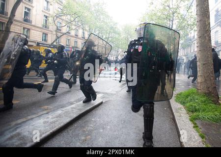 Affrontements entre manifestants et police française lors des émeutes de Mayday du 1 mai 2023 dans le centre de Paris. Beaucoup de gens se sont présentés pour exprimer leur aversion pour le président Macron et ses politiques actuelles. Sur la photo ici, la police court contre les manifestants. Banque D'Images