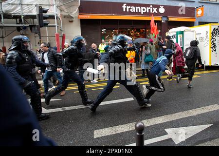 Affrontements entre manifestants et police française lors des émeutes de Mayday du 1 mai 2023 dans le centre de Paris. Beaucoup de gens se sont présentés pour exprimer leur aversion pour le président Macron et ses politiques actuelles. Sur la photo, trois policiers pourchassent les jeunes pendant les émeutes. Banque D'Images