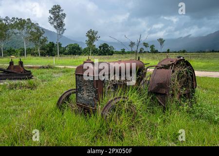 Un tracteur d'époque rouillé à côté de Murray Falls Road, Murray Upper, Queensland, Australie Banque D'Images