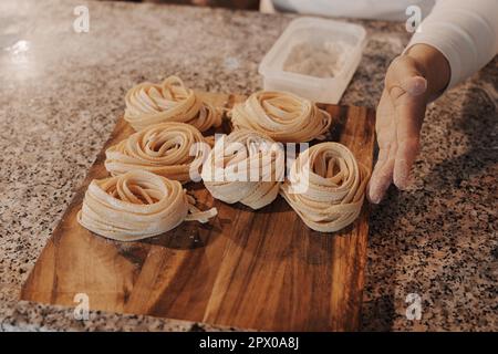 Faites de la culture à la maison en préparant des pâtes de tagliatelle roulées faites maison Banque D'Images