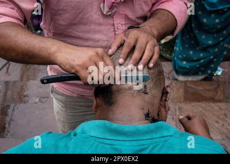 Rituel rasage de la tête sur les Ghats de Varanasi, Uttar Pradesh, Inde Banque D'Images