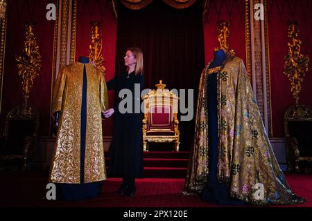 Les vêtements de Coronation, comprenant la Supertunica (à gauche) et le manteau impérial (à droite), exposés dans la salle du Trône à Buckingham Palace, Londres. Les vêtements seront portés par le roi Charles III lors de son couronnement à l'abbaye de Westminster sur 6 mai. Date de la photo: Mercredi 26 avril 2023. Banque D'Images