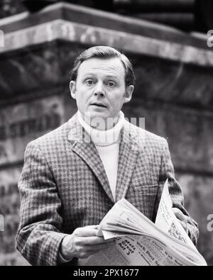 1970S HOMME PORTANT UN CHANDAIL À COL ROULÉ VESTE DE SPORT VÉRIFIÉE LISANT LE JOURNAL REGARDER LA CAMÉRA AVEC UNE EXPRESSION SÉRIEUSE - R23023 HAR001 HARS B&W OEIL-DE-CONTACT STYLES VÉRIFIÉ CONSCIENT ÉLÉGANT SINCÈRE INTÉRESSÉ SOLENNEL MODES FOCALISÉS INTENSE JOURNALISME MOYEN-ADULTE HOMME MOYEN-ADULTE NOIR ET BLANC PRUDENT DÉCONTRACTÉ CAUCASIEN ETHNICITÉ EARNEST HAR001 INTENTION OLD FASHIONECK TURTLENECK Banque D'Images