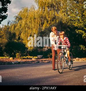 1970S HOMME PÈRE AIDER JEUNE ADOLESCENT GARÇON FILS À FAIRE LE PREMIER VÉLO PLEINE GRANDEUR - KB13458 PHT001 HARS PEUR JUVÉNILE SÉCURITÉ RIDE SONS FAMILLES STYLE DE VIE SATISFACTION PARENT CÉLÉBRATION RURALE VIE VIE COPIE ESPACE PLEINE LONGUEUR PHYSIQUE FITNESS PERSONNES S'OCCUPANT DES HOMMES RISQUE SPIRITUALITÉ PÈRES SUCCÈS AVENTURE CHOIX DADS EXCITATION SAVOIR RÉCRÉATION INNOVATION OPPORTUNITÉ MENTORAT CONCEPTUEL ÉLÉGANT SOUTIEN DÉBUTANT COOPÉRATION CROISSANCE JEUNES MI-ADULTES MI-ADULTES HOMME PRÉ-ADOLESCENT PRÉ-ADOLESCENT PRÉCISION DE GARÇON CAUCASIEN ETHNICITÉ ANCIEN MODE Banque D'Images