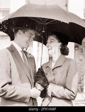 1950S RIRE SOURIANT COUPLE HOMME FEMME PARTAGEANT UN PARAPLUIE DANS LA PLUIE - S6841 HAR001 HARS VIEUX TEMPS OCCUPÉ NOSTALGIE MODE ANCIENNE 1 STYLE RIRE ÉQUILIBRE TRAVAIL D'ÉQUIPE FORTE JOIE HEUREUSE STYLE DE VIE FEMMES MARIÉE ÉPOUX AMITIÉ FEMMES PERSONNES S'OCCUPANT HOMMES B&W PARTENAIRE DATANT BONHEUR GAIE AVENTURE PROTECTION ET EXCITATION OCCASION D'ATTIRER LES SOURIRES CONNEXION COUR JOYEUSE ÉLÉGANT SOUTIEN ATTACHEMENT PERSONNEL POSSIBILITÉ AFFECTION COOPÉRATION ÉMOTION MI-ADULTE MI-ADULTE HOMME MI-ADULTE FEMME RELAXATION ACTIVITÉ SOCIALE TOGETHERNESS ÉPOUSES NOIR ET BLANC ORIGINE ETHNIQUE CAUCASIENNE Banque D'Images