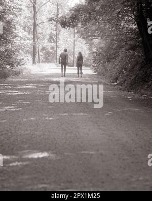 1970S BACK VIEW ANONYME SILHOUETTED HOMME ET FEMME MARCHANT SUR UNE VOIE DE PAYS OMBRAGÉE - S19210 HAR001 HARS AMITIÉ PLEINE LONGUEUR FEMMES PERSONNES PITTORESQUE INSPIRATION MÂLES SÉRÉNITÉ SILHOUETTES SPIRITUALITÉ B&W LANE OUTLINE ÉTÉ RÊVES AVENTURE OMBRAGÉE LOISIR SILHOUETTÉ ET DIRECTION DE LOISIRS RELATIONS AMICALES ANONYME DOUX FOYER DÉTENTE SAISON TOGETHERNESS JEUNE ADULTE HOMME JEUNE ADULTE FEMME NOIR ET BLANC HAR001 À L'ANCIENNE Banque D'Images