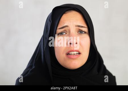 Une jeune femme inquiète vêtue de vêtements islamiques traditionnels Banque D'Images