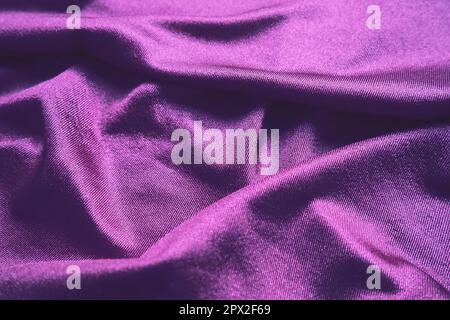 Tissu velours, semblable à la soie. Textiles dans des plis et de belles vagues. Tons violet, rose, magenta sur la drapery. Matériel de couture pour les soirées dres Banque D'Images