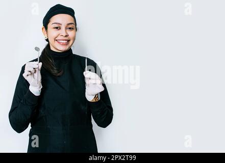 Portrait d'un dentiste avec outils dentaires, portrait d'une femme dentiste avec miroir et sonde dentaire, femme dentiste isolée avec outils dentaires Banque D'Images