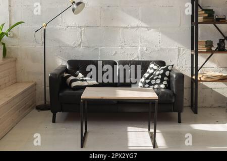 Élégant canapé noir dans le salon moderne intérieur. Banque D'Images