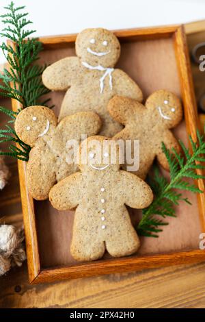 Gingerbread Man. Cuisiner des biscuits de pain d'épice à la maison se trouve sur un plateau en bois Le concept des fêtes de Noël et du nouvel an Banque D'Images