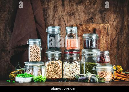 Légumineuses et haricots secs, crus et frais dans des pots en verre. Lentilles, pois chiches, haricots mung, soja. Aliments sains, protéines végétaliennes, micronutriments et fibres Banque D'Images