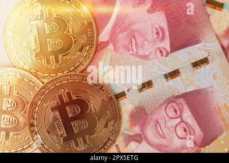 Bitcoin placé sur le dessus d'une centaine de milliers de rupias billet de banque. Concept de trading de crypto-monnaie Banque D'Images