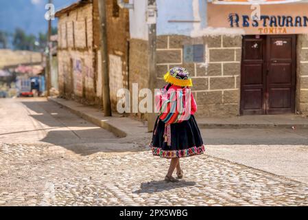 Province de Paucartambo, Pérou - 4 septembre 2011. Une femme mûre marche dans une petite ville péruvienne portant des vêtements traditionnels, y compris une couverture colorée. Banque D'Images