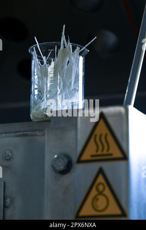 Osterhausen, Allemagne. 28th avril 2023. Un verre de laboratoire contient des fibres qui ont été séparées d'un plastique renforcé de fibre de verre. La société Deutsche Vacuumtrockner GmbH développe des procédés de séchage spéciaux qui permettent le recyclage de matériaux dont les composants seraient autrement inséparables. Ce procédé est également utilisé pour les produits agricoles, l'industrie cosmétique, le secteur alimentaire et l'industrie pharmaceutique. Credit: Heiko Rebsch/dpa/Alay Live News Banque D'Images