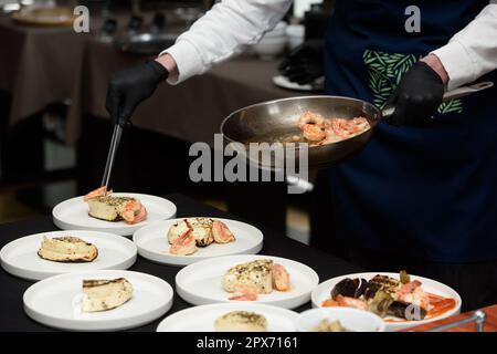 Le chef du restaurant prépare des en-cas au fromage grec traditionnel saganaki, frits dans une poêle ou grillés Banque D'Images