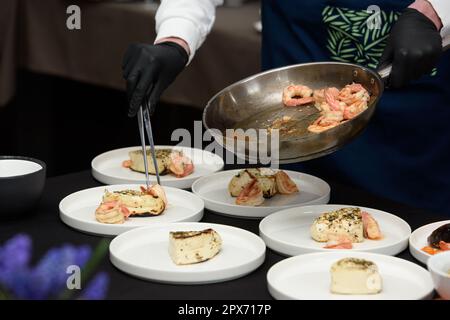 Le chef du restaurant prépare des en-cas au fromage grec traditionnel saganaki, frits dans une poêle ou grillés Banque D'Images