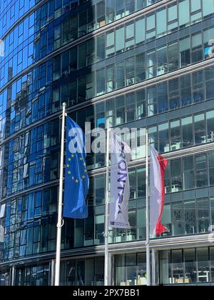 VARSOVIE, POLOGNE - 15 JUILLET 2022 : vue sur les poteaux avec différents drapeaux près du gratte-ciel du Spire de Varsovie Banque D'Images