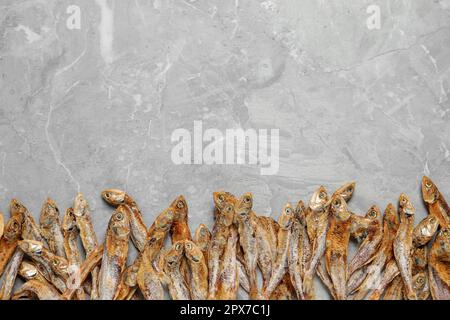 Savoureux anchois séchés sur une table en marbre gris clair, plat. Espace pour le texte Banque D'Images