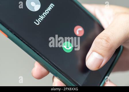 Homme en attente d'un appel de téléphone mobile à partir d'un numéro inconnu. Escroquerie, fraude ou hameçonnage avec le concept de smartphone. homme répondant à un appel entrant. Banque D'Images