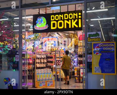 Un acheteur entre dans un magasin pour regarder les produits à vendre à Don Don Donki, une chaîne de magasins à prix réduits japonais, dans la région de Silom, Bangkok, Thaïlande. Banque D'Images