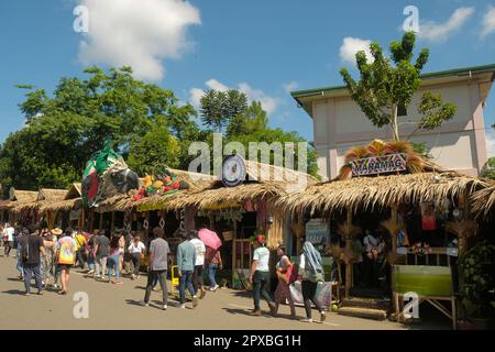 Malaybalay City, Philippines - les gens marchent dans une rue animée avec des cabanes nipa décorées comme des magasins locaux pop-up au festival Kaamulan annuel à Bukidnon. Banque D'Images