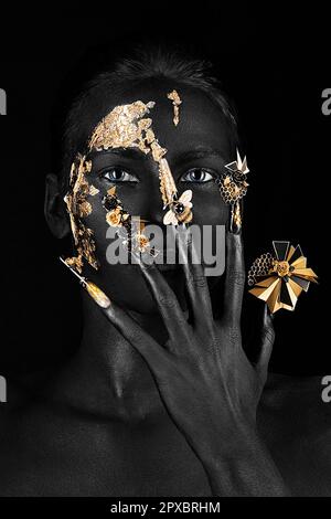 Belle femme avec maquillage d'art noir, ongles longs créatifs. Manucure de conception. Visage de beauté. Photo prise en studio. Banque D'Images