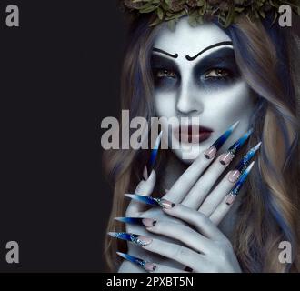 Portrait d'une horrible peur Corpse Bride en couronne, avec les fleurs mortes, Halloween maquillage et manucure long.Design d'ongles.Photo prise en studio Banque D'Images