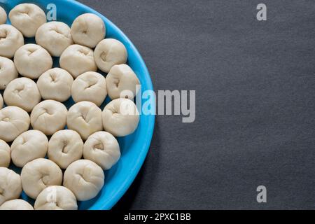 Une assiette de petite pâte à pain crue fraîchement fermentée maison sur fond blanc Banque D'Images