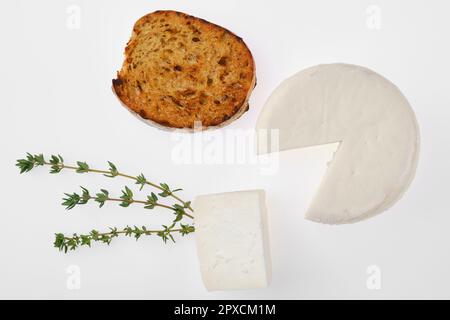 Vue de dessus d'une petite tête de fromage de chèvre et d'un morceau de pain grillé Banque D'Images
