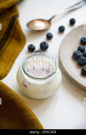 Ingrédients pour un petit déjeuner sain, pot en verre avec yaourt frais et jus de myrtille, Italie, Europe Banque D'Images