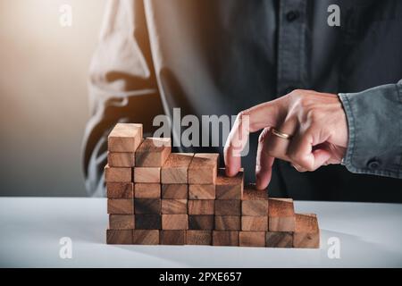 Le symbole « Business Two finger » qui monte sur des blocs de bois forme l'escalier pour grimper l'échelle de carrière, remonter l'escalier, éviter l'effondrement ou l'accident Banque D'Images