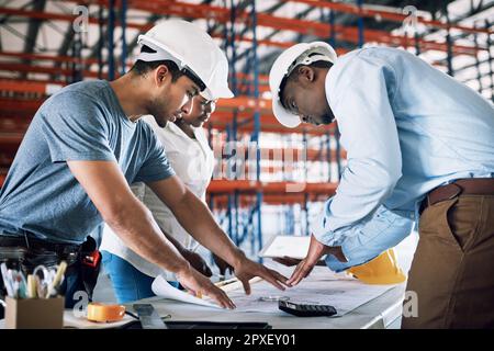 Une collaboration efficace permet un délai d'exécution rapide. un groupe de constructeurs ayant une réunion sur un chantier de construction. Banque D'Images