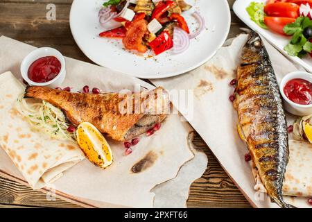 maquereau grillé et bar.Salade de légumes frais.Service sur une planche en bois sur une table rustique.Menu du restaurant barbecue, une série de photos de Banque D'Images