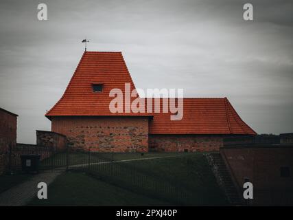 Un bâtiment aux carreaux rouges est bien placé contre la ligne d'horizon, les vestiges du mur historique de la ville de Vilnius Banque D'Images